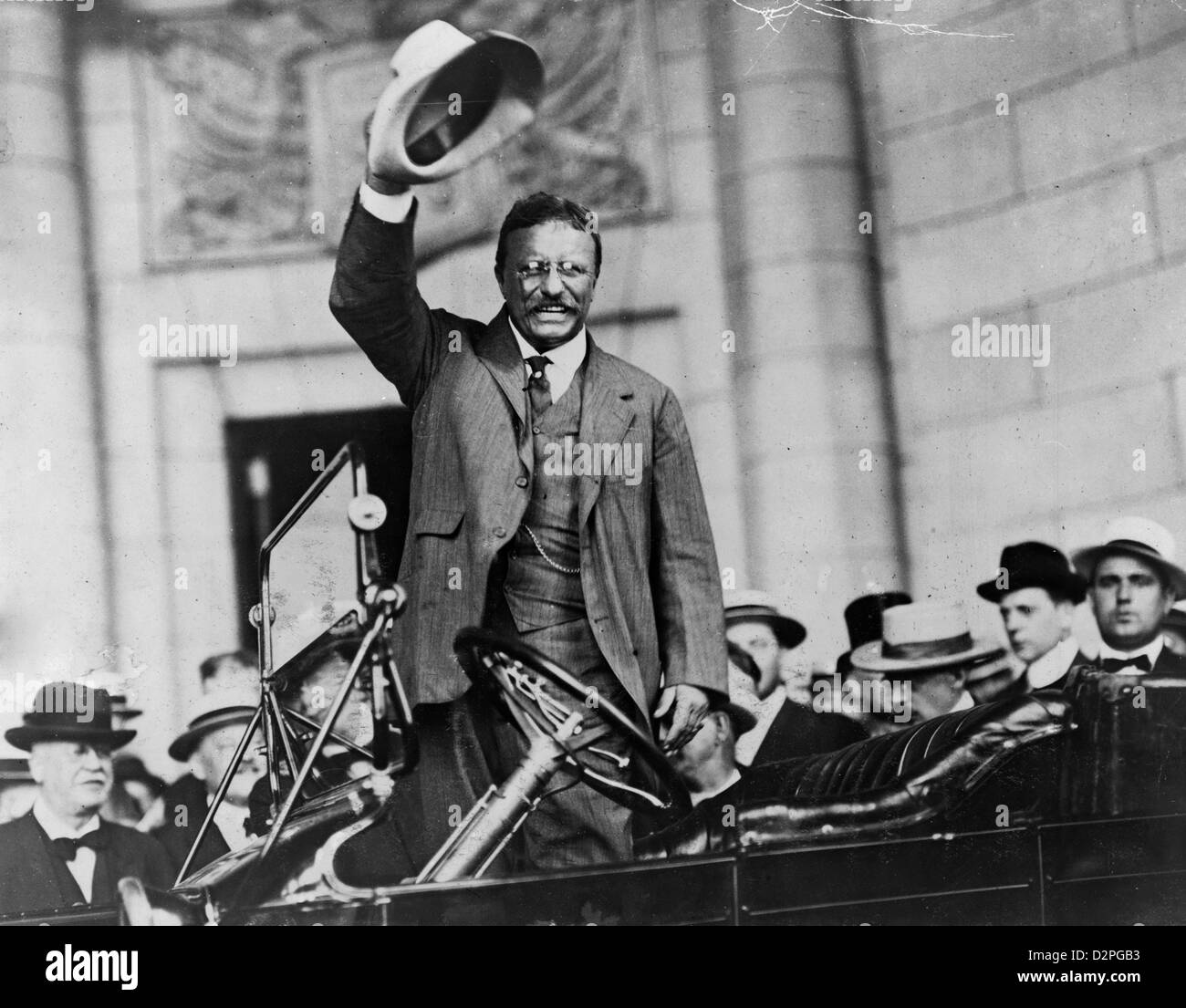 Theodore Roosevelt, three-quarter length portrait, standing up in car, waving hat (between 1909 and 1932) Stock Photo