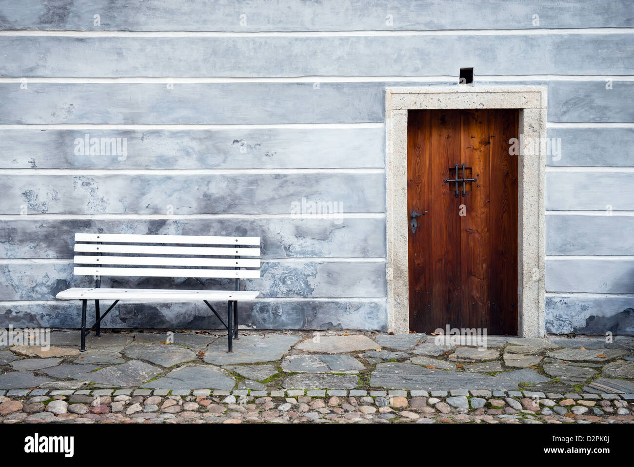 wooden door with blue grungy house facade and white bench Stock Photo ...