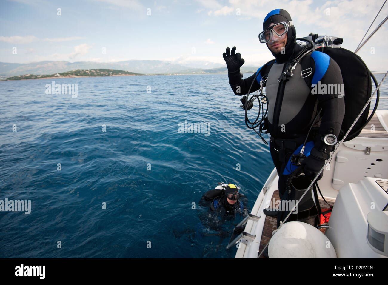 Scuba diver standing on the yacht and ready to dive Stock Photo Alamy