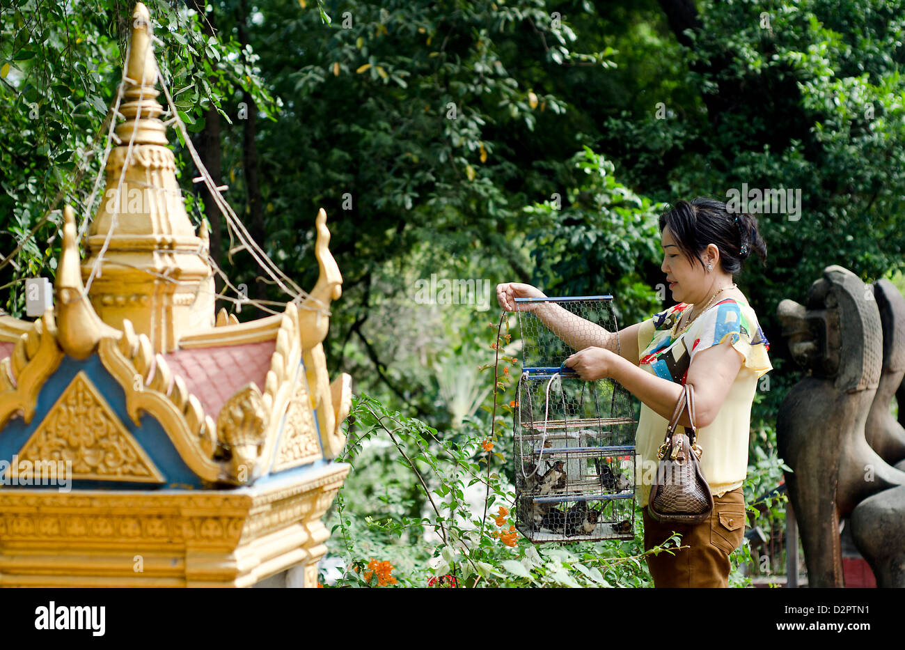 Woman frees bird at Wat Phnom ,Buddhist shrine in Phnom Penh. Stock Photo