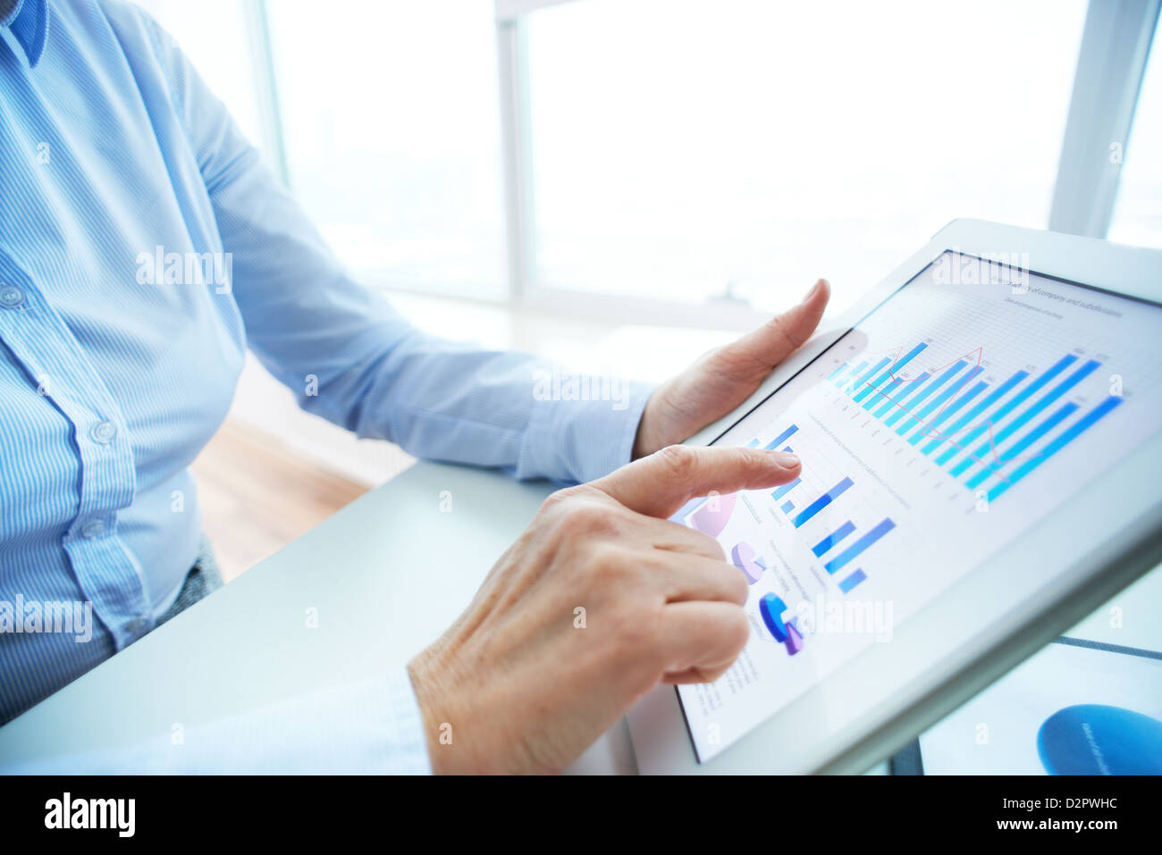 Image of human hand pointing at touchscreen with business document ...
