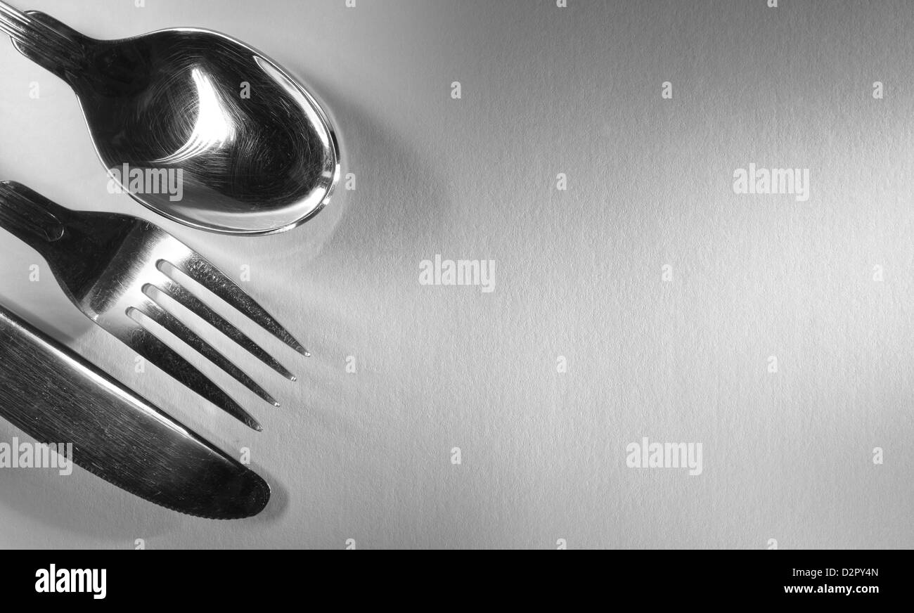 Spoon, fork and knife set in the corner on textured background Stock