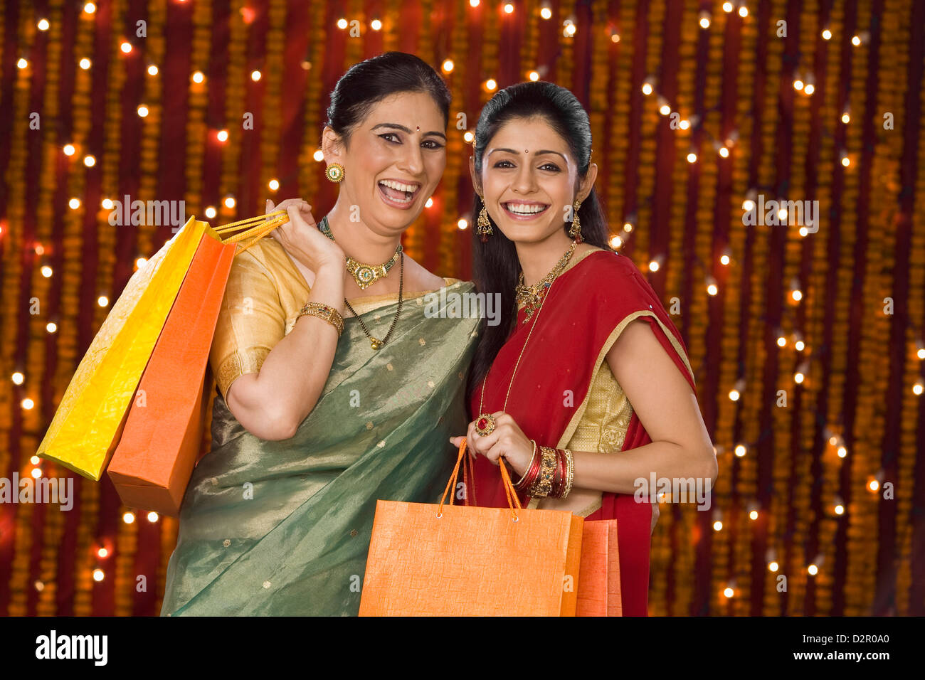 Portrait of women holding shopping bags and smiling Stock Photo - Alamy
