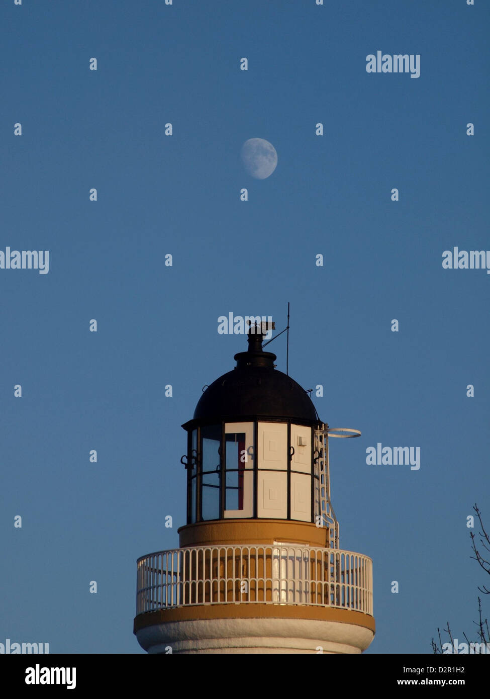The moon above a lighthouse in the Scottish Highland Town of Cromarty. Stock Photo