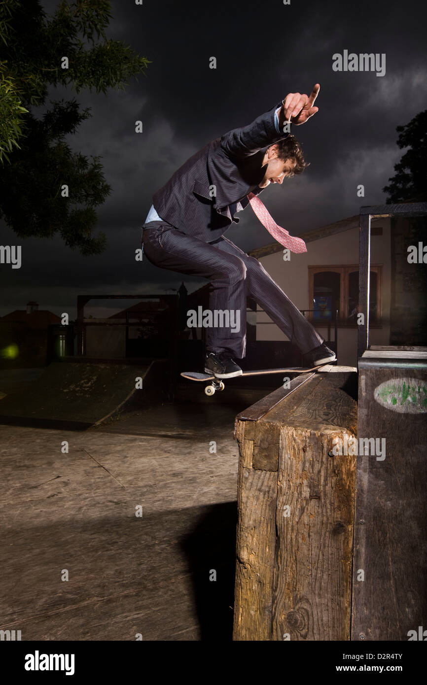 Man in suit skateboarding at night Stock Photo Alamy