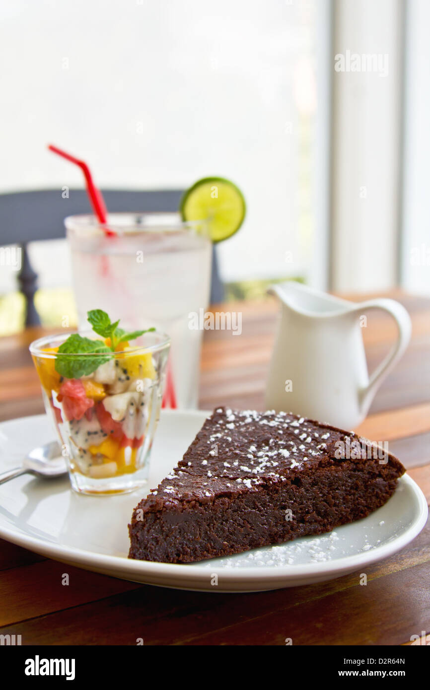 Chocolate fondant cake with fruit salad and lime juice Stock Photo