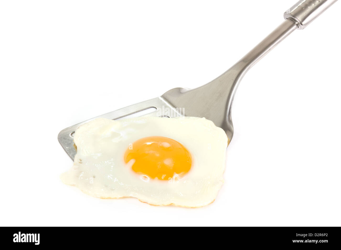 Fried egg on a silver spatula on a white background Stock Photo