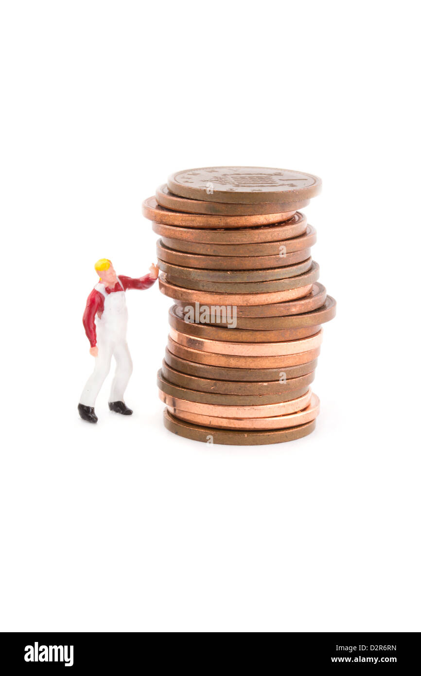 Miniature figure holding up a stack of coins on white Stock Photo