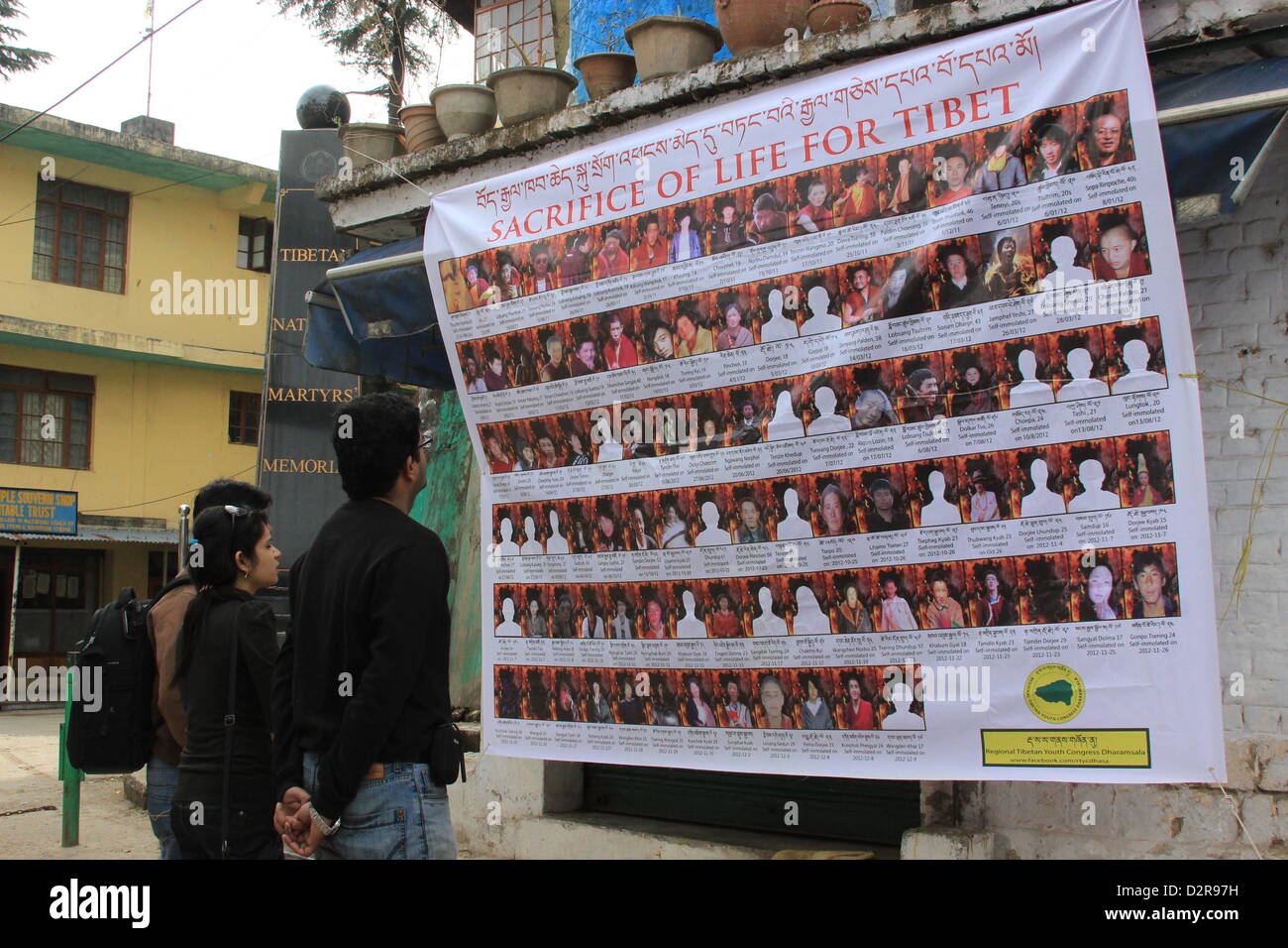 Three Indians stand in front of a sign with the portraits of Tibetans who performed self-immolation in Dharamsala, India, 23 January 2013. Photo: Foreen Fiedler Stock Photo