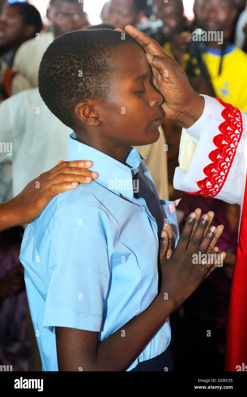 Boy being blessed during a roman catholic confirmation ceremony in Bagamoyo, Tanzania Stock Photo