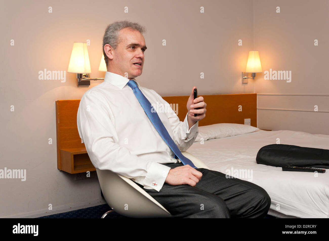Business man sitting in hotel room in animated conversation. Stock Photo