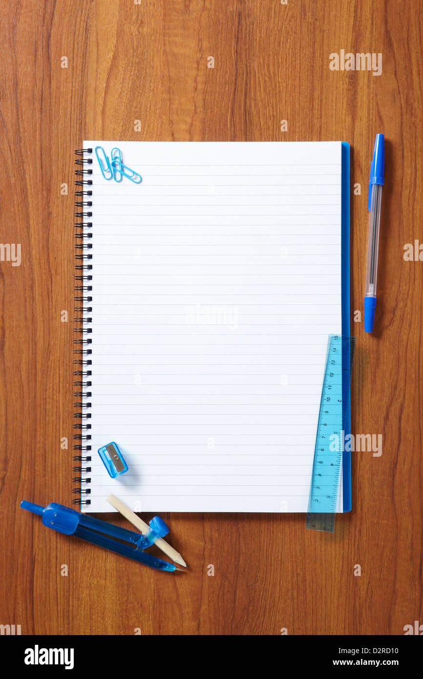 Back to School pupils note pad and stationary on wooden school desk from above Stock Photo