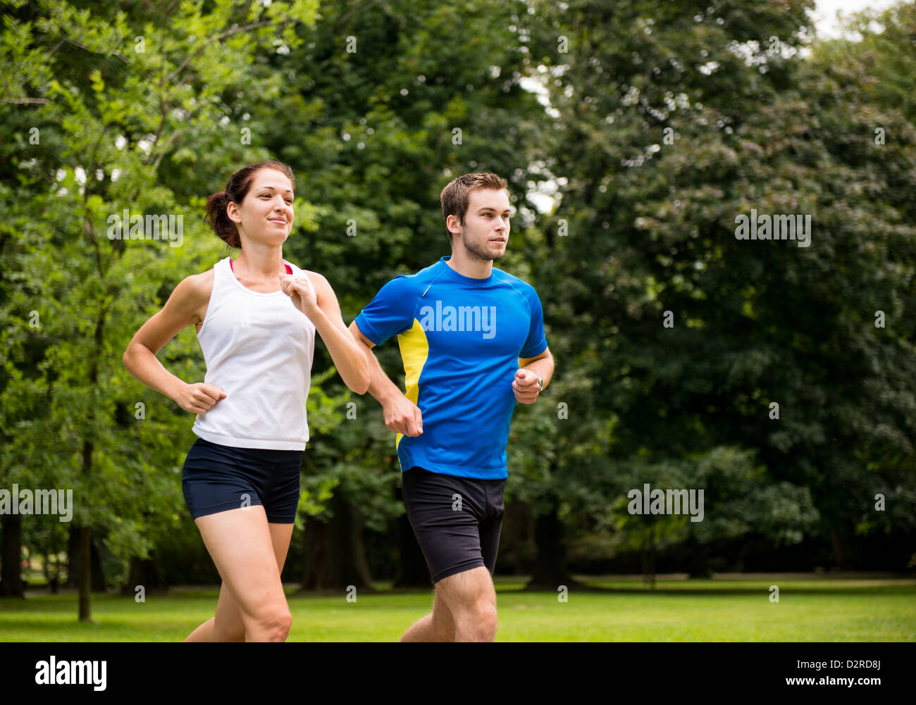 Fitness couple - young man and woman jogging outdoor in nature Stock Photo