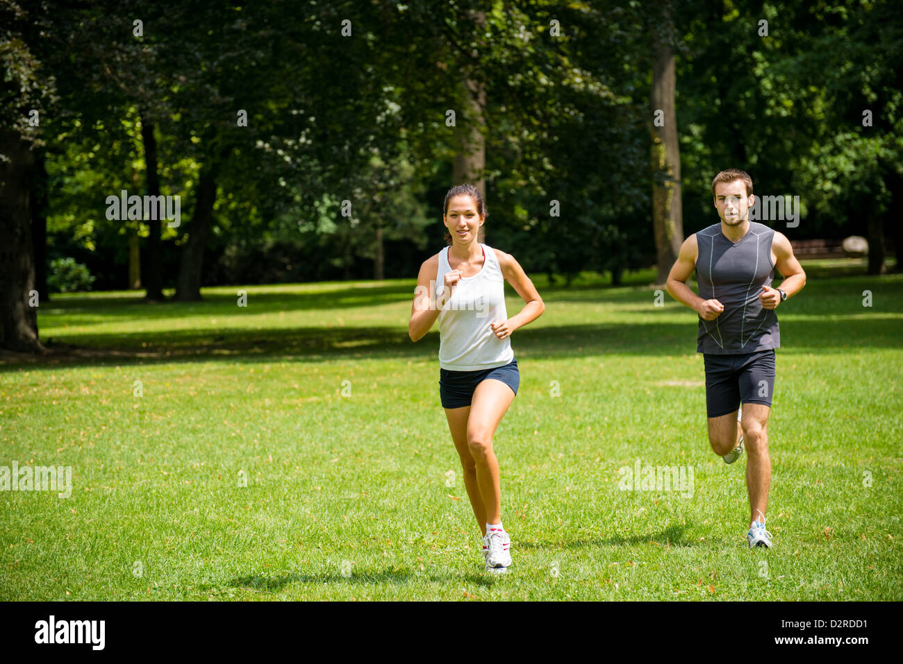 Sport couple - young man and woman jogging outdoor in nature Stock Photo