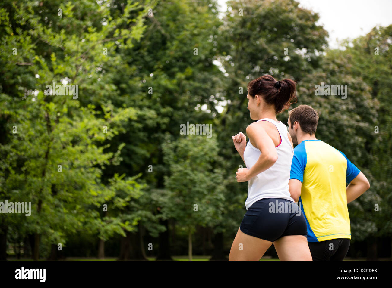 Fitness couple - young man and woman jogging in nature - rear view Stock Photo