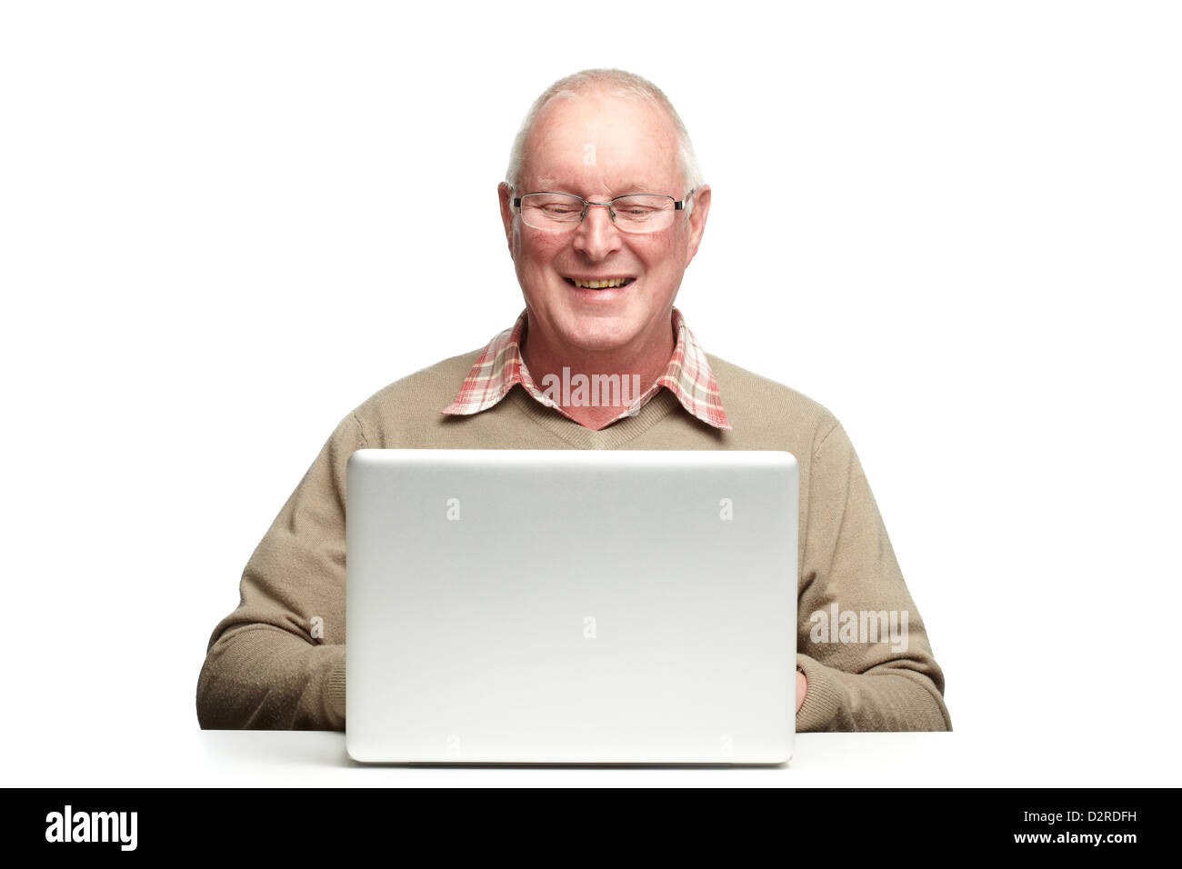 Senior man using laptop whilst smiling, on white background Stock Photo ...