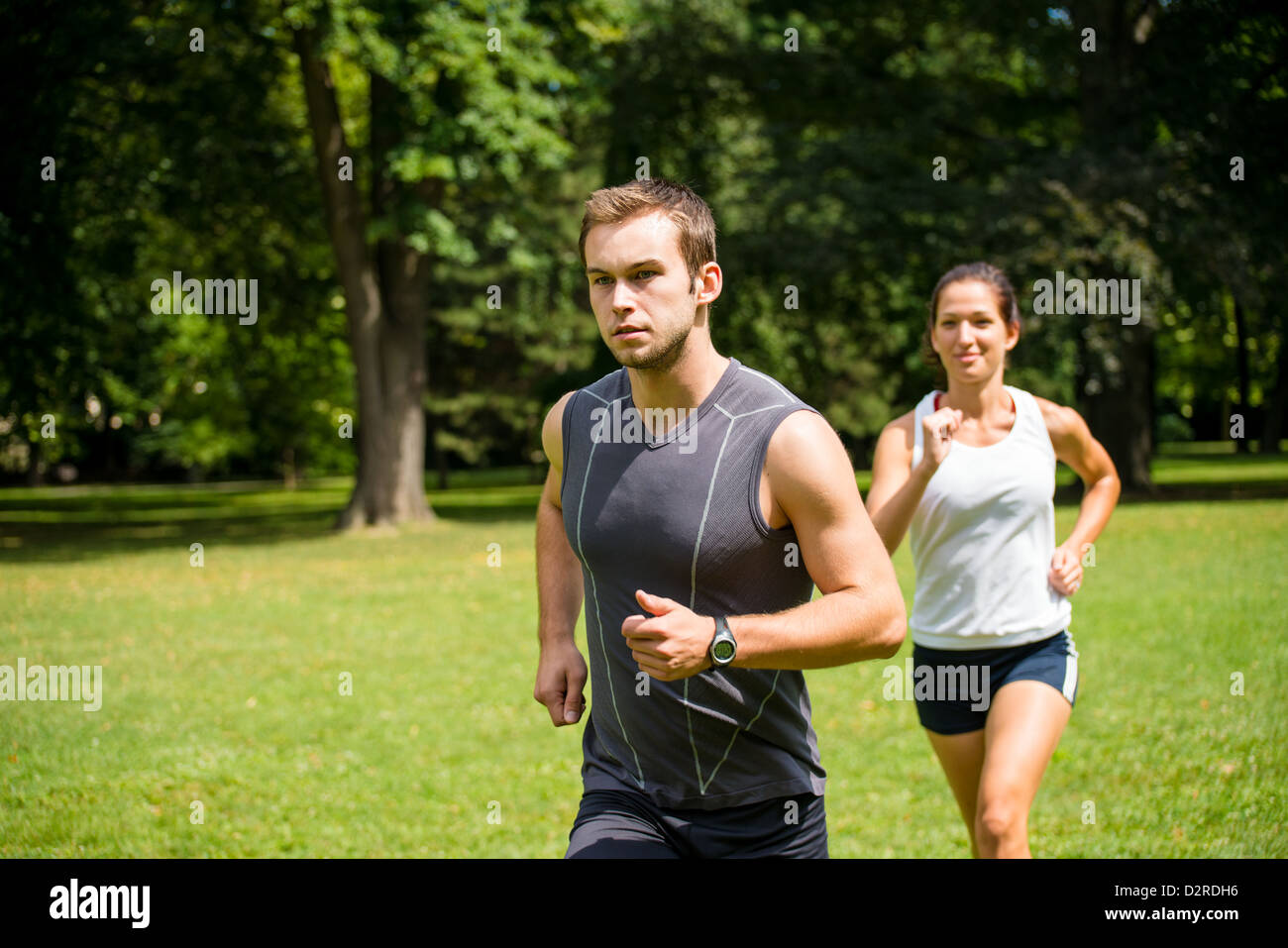 Fitness couple - young man and woman jogging outdoor in nature Stock Photo