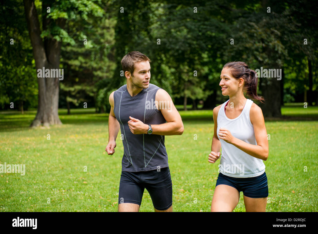 Young man and woman jogging outdoor and looking on each other Stock Photo