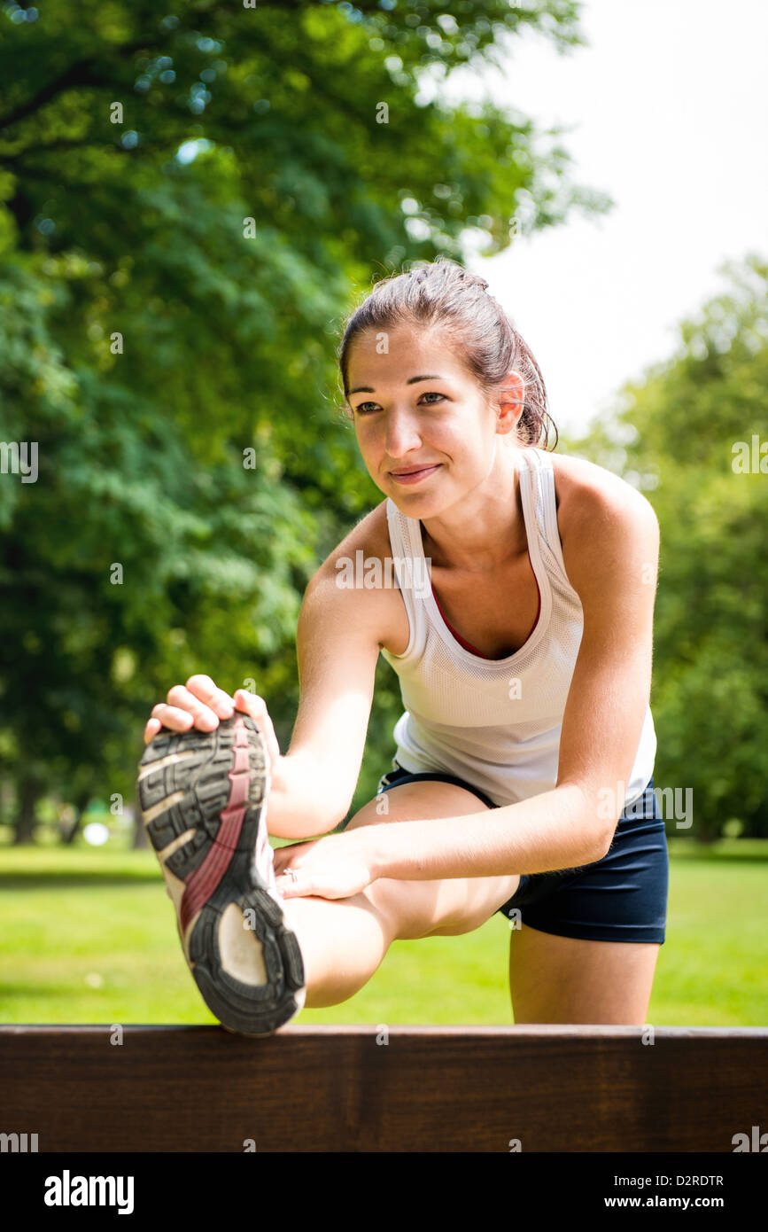 Young fitness woman stretching muscles before sport activity - outdoor in park Stock Photo