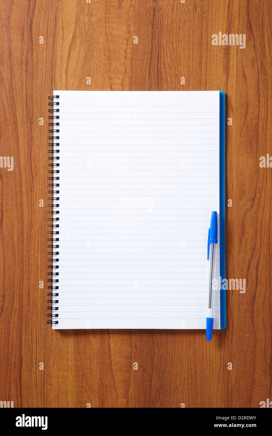 Back to School pupils note pad and pen on wooden school desk from above Stock Photo