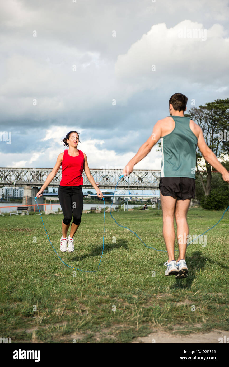 Young fitness couple exercising outdoor - jumping with skipping rope Stock Photo