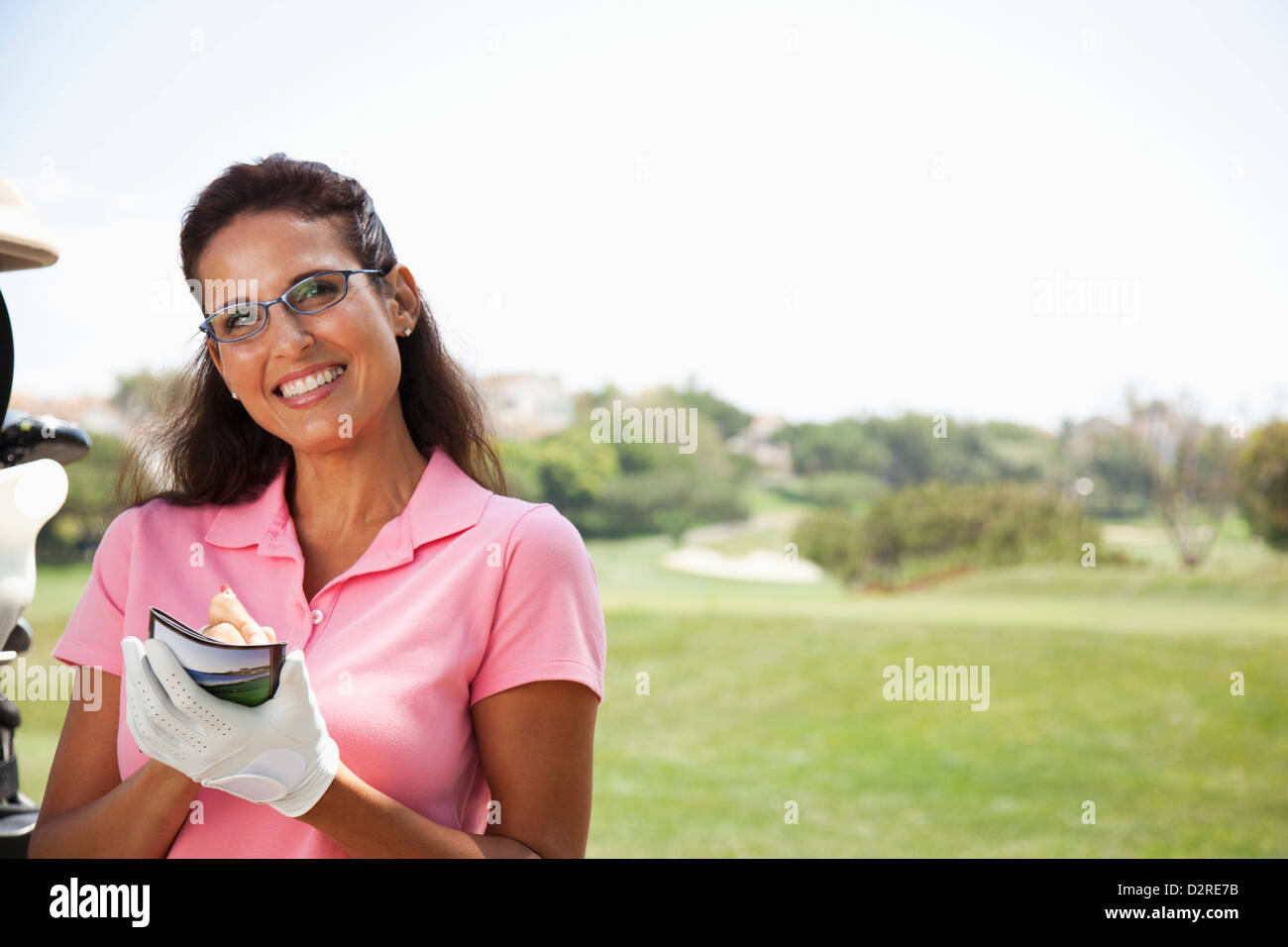 Woman keeping score during golf game Stock Photo