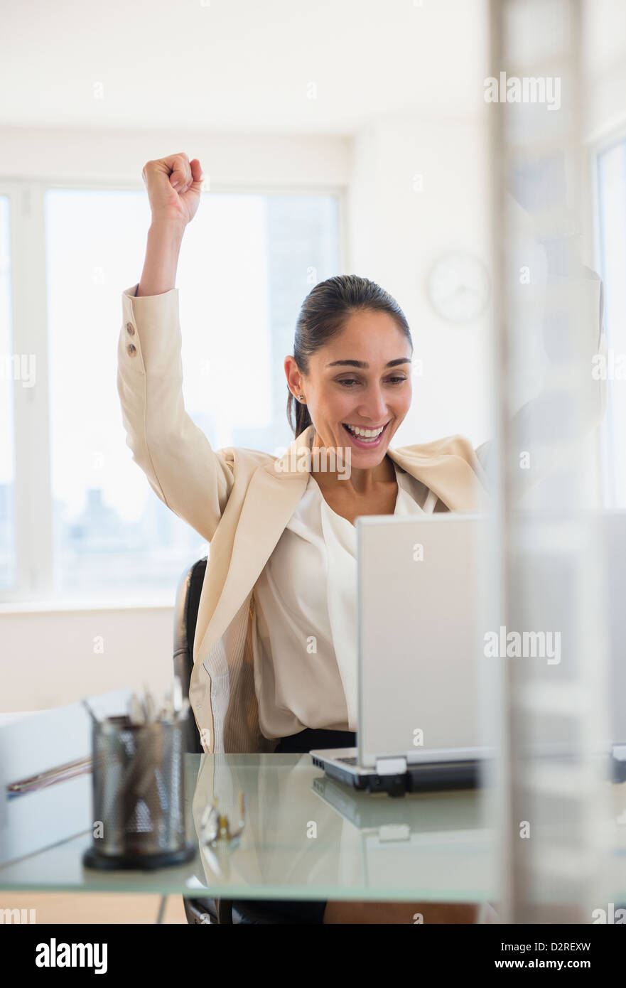 Caucasian businesswoman cheering at laptop Stock Photo