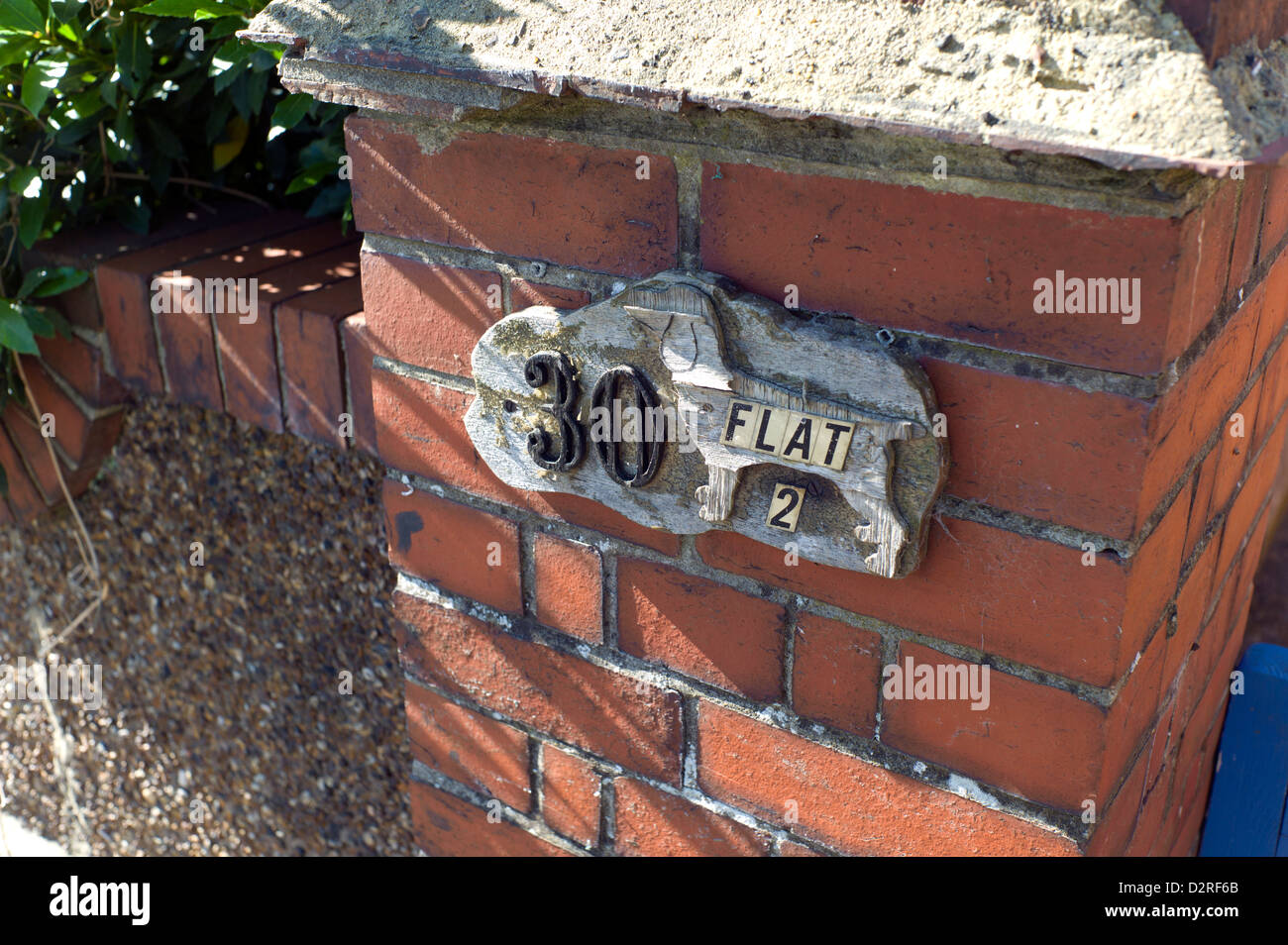 Old house sign, brick pillar, handmade, wood, dog Stock Photo