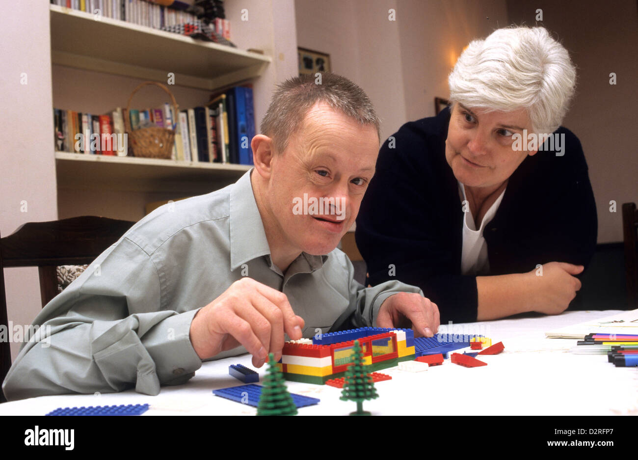 Down syndrome young man with teacher building lego blocks Stock Photo -  Alamy