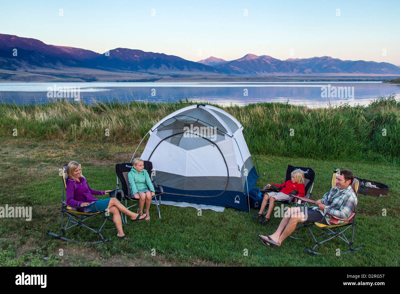 Family sits around the tent while camping at Ennis Lake near Ennis
