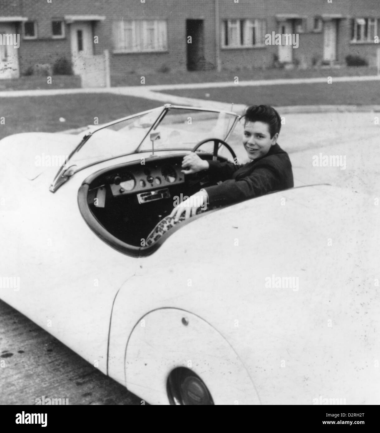 CLIFF RICHARD UK pop singer with his first car outside the family home in Ealing about 1958 Stock Photo