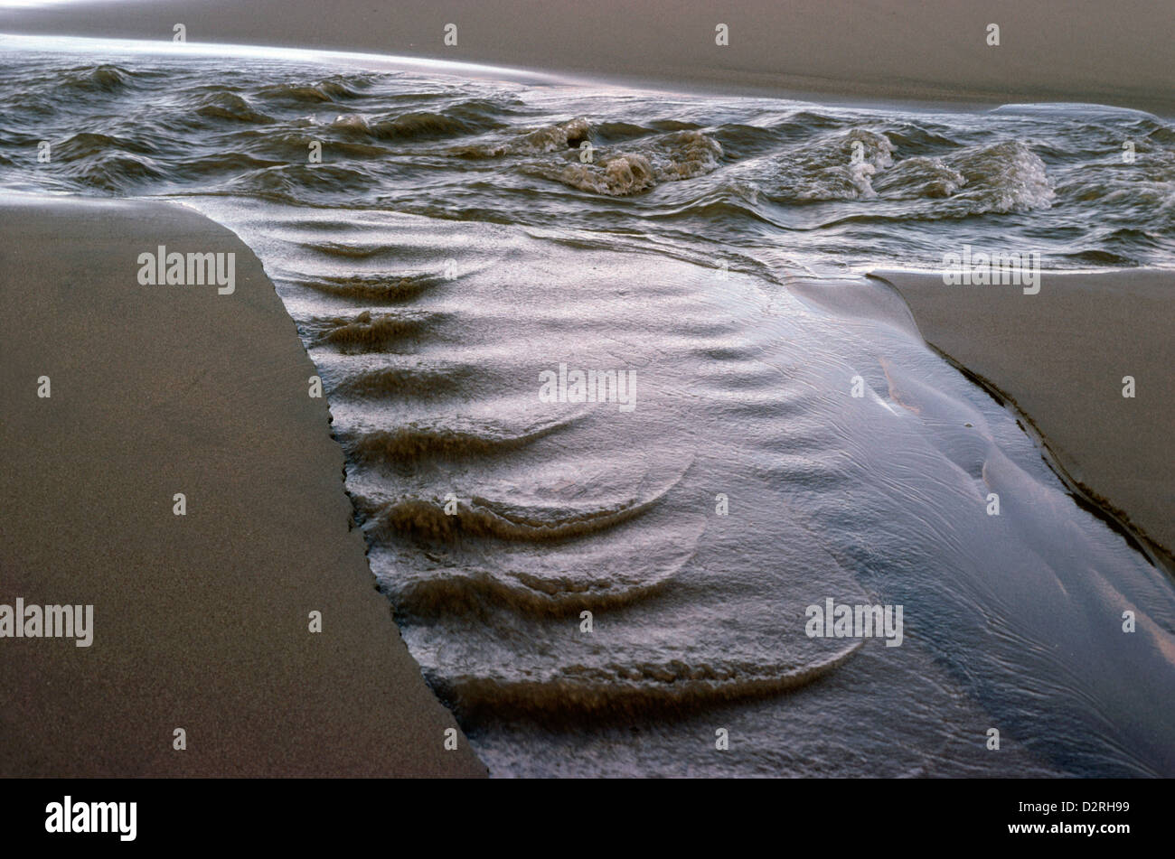 River Hoffnant flowing across Penbryn Beach, Cardigan Bay, West Wales, UK Stock Photo