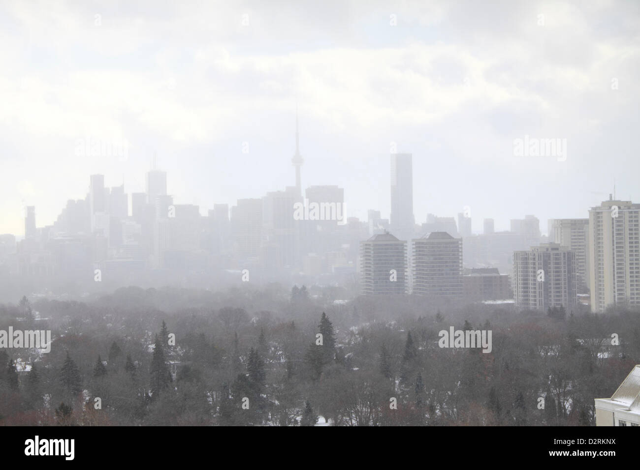 Snow squall moving through midtown Toronto with reduced local visibilities. Temperature dipped 18 celsius degrees from the warmest day on record overnight. Stock Photo