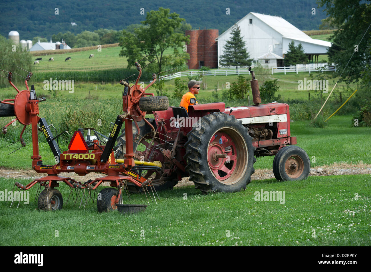 Man operating an antique tractor on a farm Stock Photo