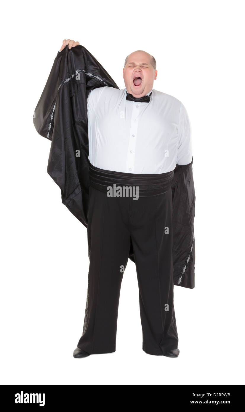 Very overweight elegant fat man yawning after a night out as he strips off his dinner jacket, studio portrait on white Stock Photo