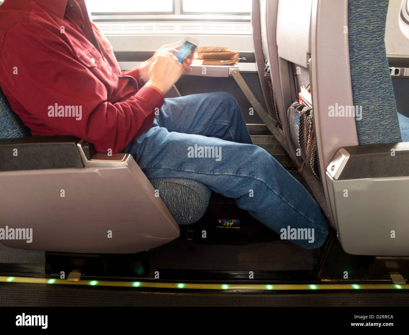 Mature Passenger Using a Smartphone on Amtrak Train, USA Stock Photo
