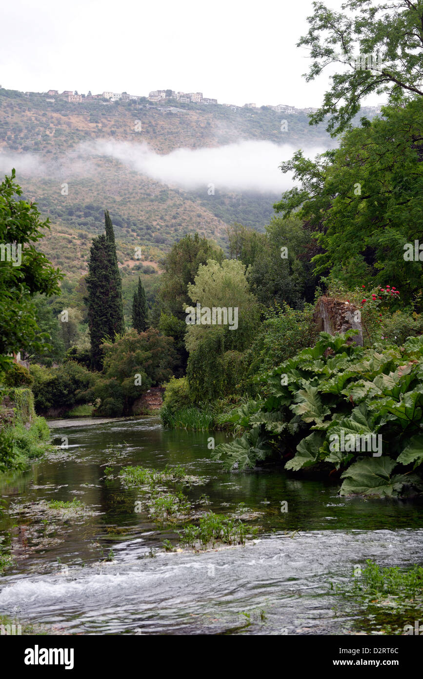 View along the romantic river and the ruins of the medieval village. Garden of Ninfa. Lazio. Italy. Stock Photo