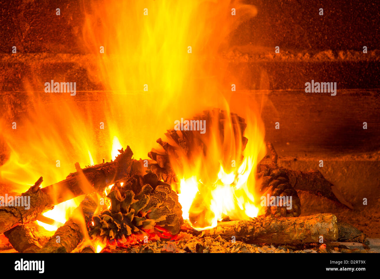 Burning Firewood In Chimney With Pine Cones And Fire Stock Photo