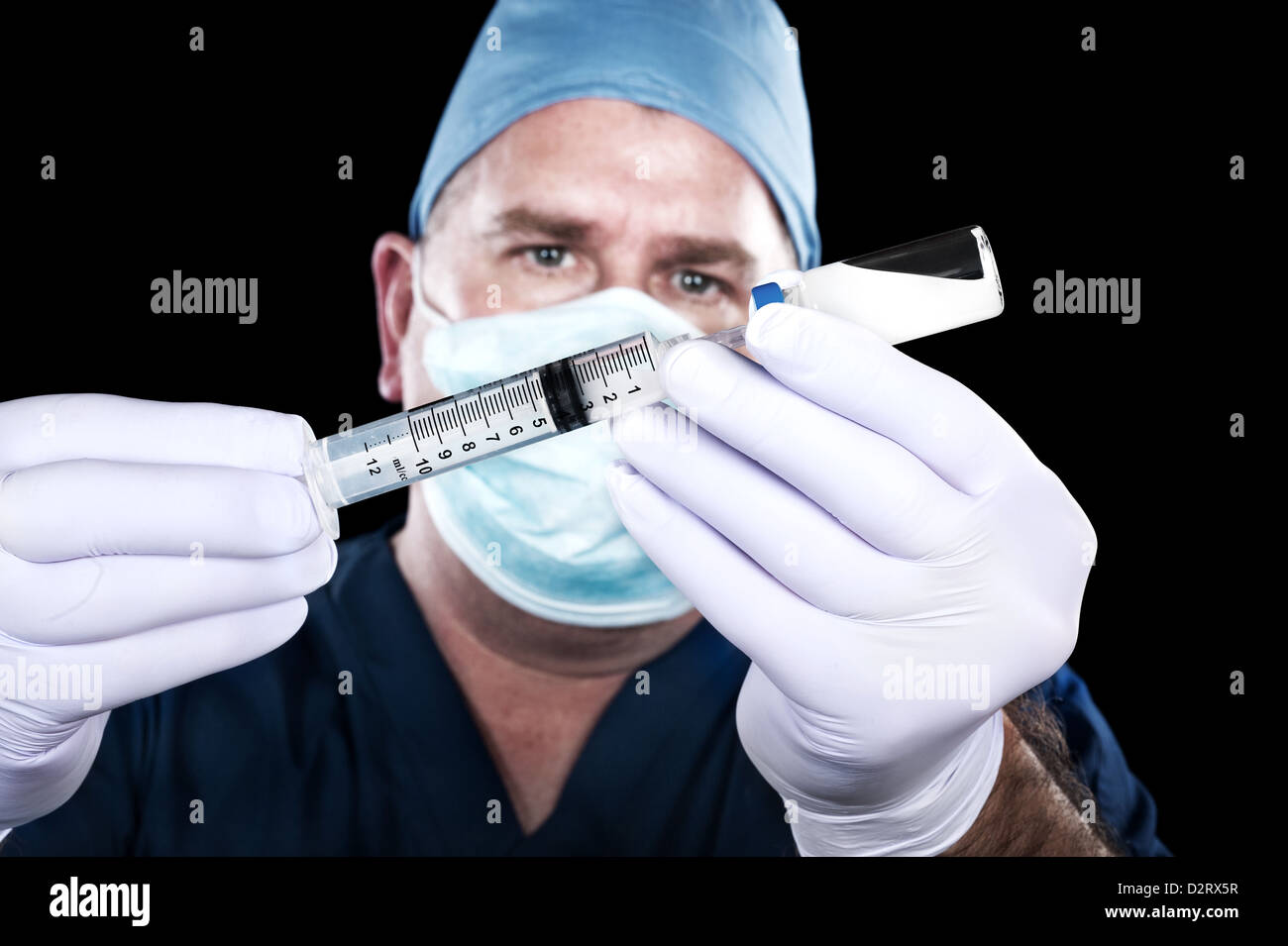 A doctor draws narcotics from a vial in preparation to inject a patient. Stock Photo