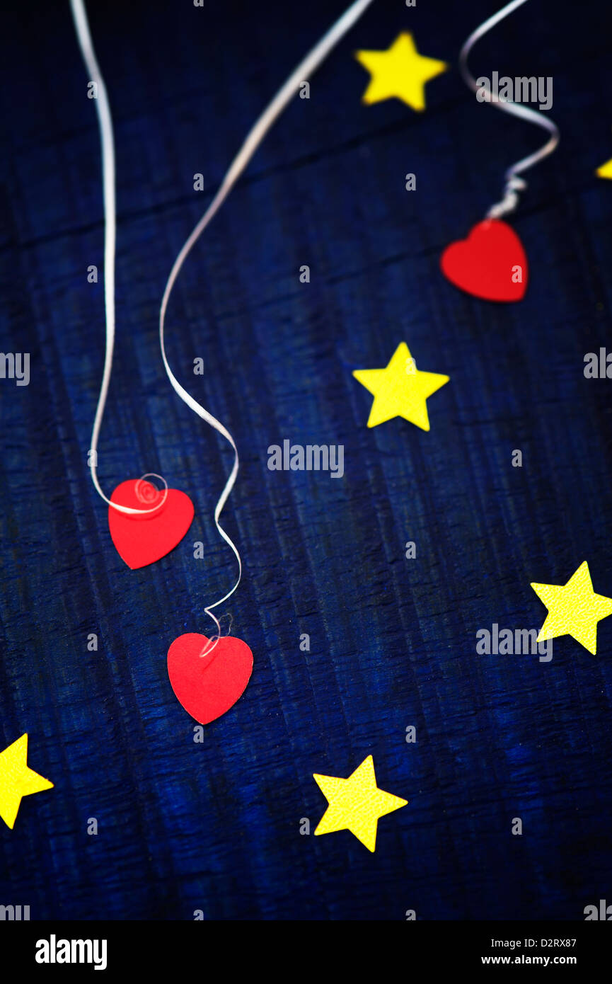 Shiny gold stars and red love hearts on a blue wood background Stock Photo