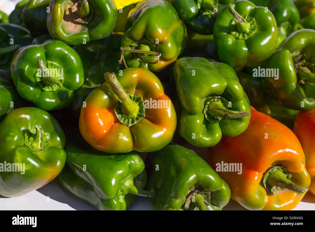 green peppers stacked in a row at market vegetables food Stock Photo