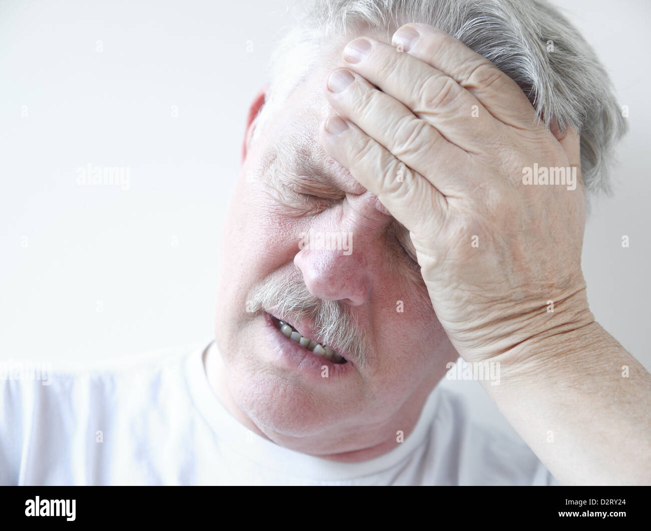 senior with hand on forehead and frown Stock Photo