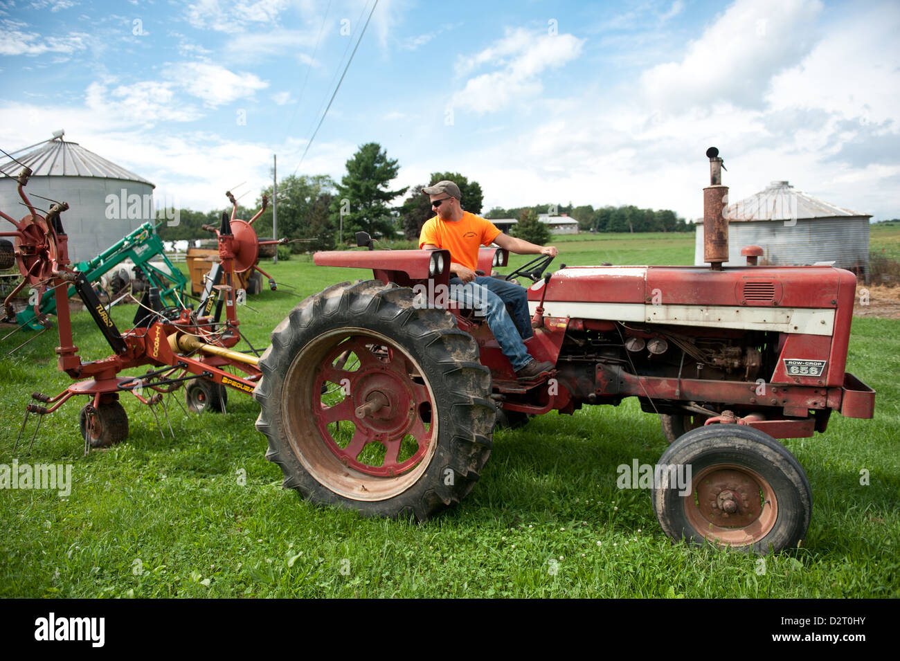 Man operating an antique tractor on a farm Stock Photo