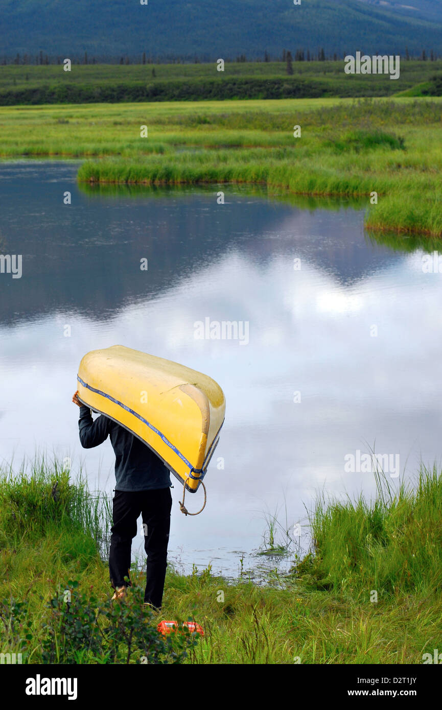Carrying a canoe to the Moose Ponds at the start of a canoe trip on the