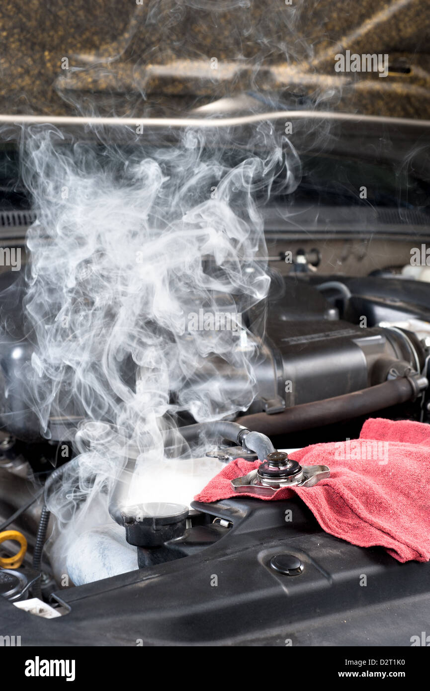 An overheated car engine smokies as the radiator cools down. Stock Photo