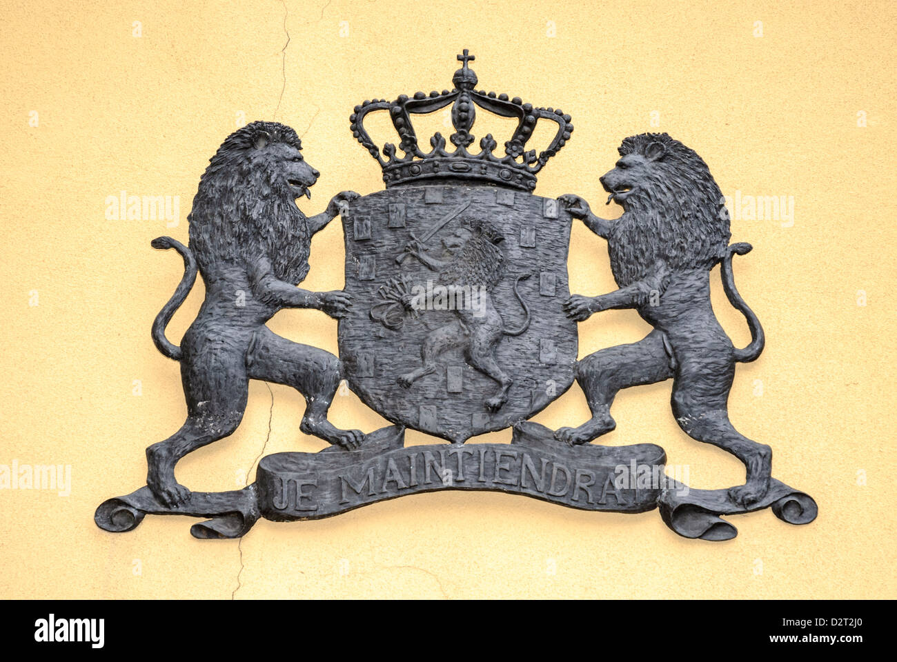 Coat of arms in metal, on a yellow wall. Stock Photo