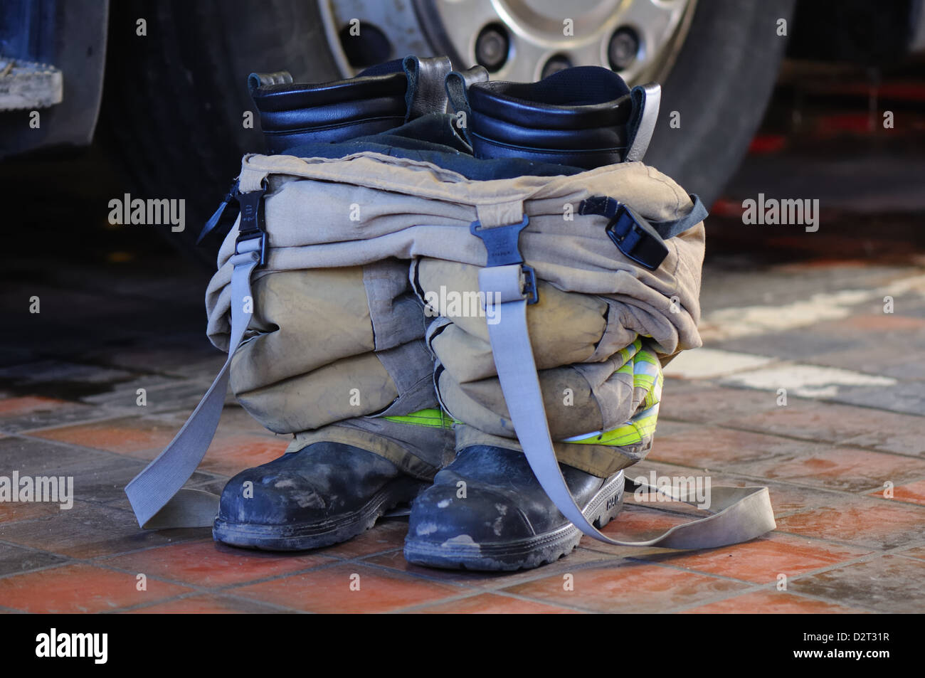 Firefighters boots and over trousers beside fire truck Stock Photo