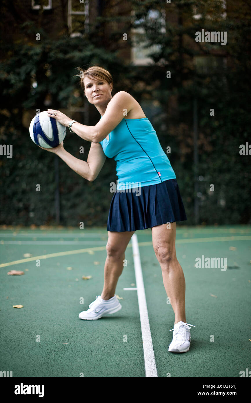 Netball player on pitch holding ball in preparation to throw Stock Photo