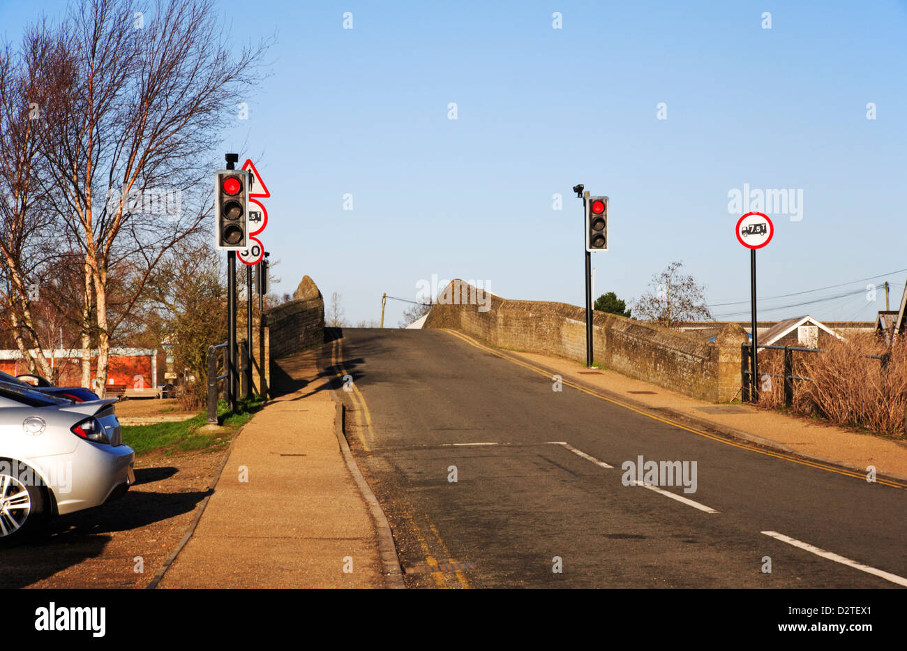 The old A149 medieval bridge over the River Thurne with traffic lights at Potter Heigham