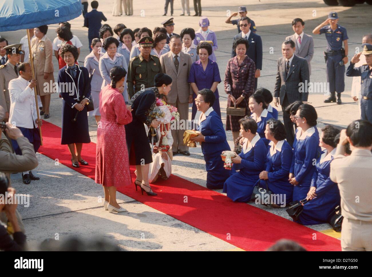 Queen Sirikit of Thailand and her daughter Princess Siringhorn (red dress) in March 1980 after returning from a two months journey to the US and Germany. Stock Photo